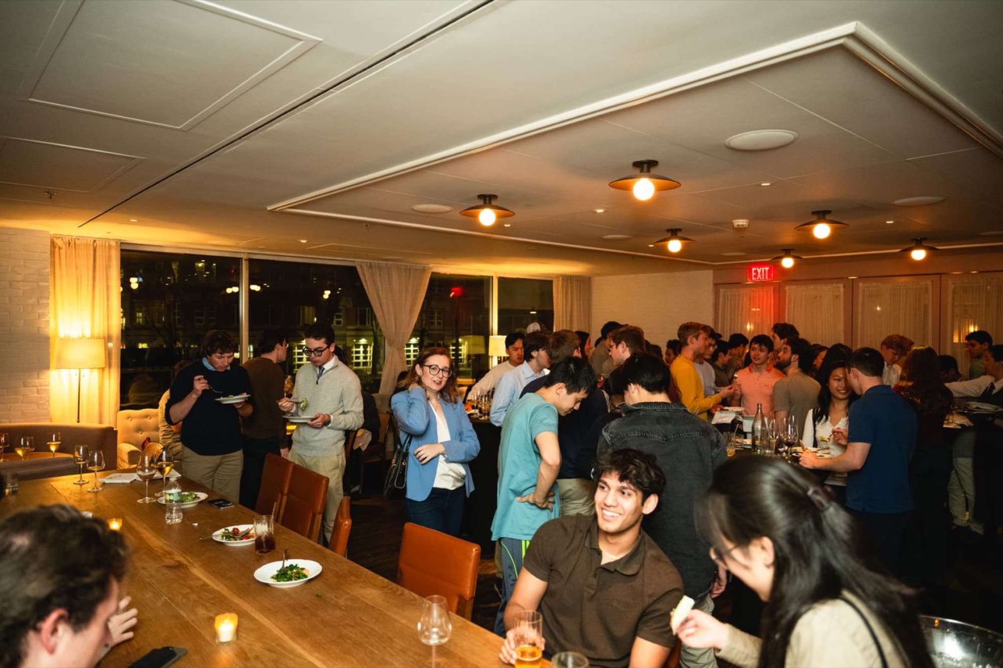 Packed Camel dinner, students and guests, city skyline behind